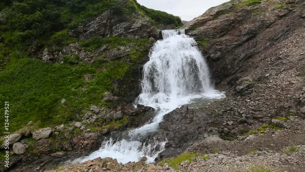 Beautiful view of cascade waterfall in Mountain Range Vachkazhets. Summer mountain landscape of Kamchatka Peninsula. Russian Far East, Eurasia. Beautiful view of cascade waterfall in Mountain Range Vachkazhets. Summer mountain landscape of Kamchatka Peninsula. Russian Far East, Eurasia.