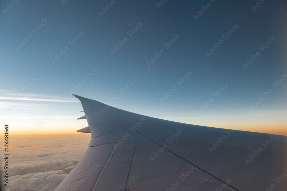 Airplane wing with sunset and beautiful cloudy Airplane wing with sunset and beautiful cloudy