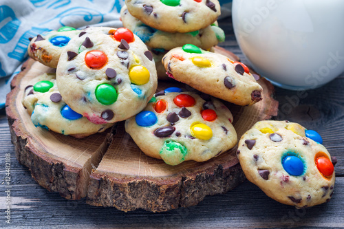 Shortbread cookies with multi-colored candy and chocolate chips on wooden board, horizontal