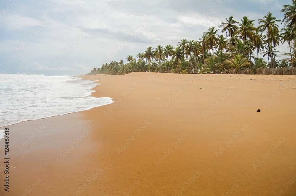 Naklejka premium Tropical Azuretti beach on the Atlantic ocean coast in Grand Bassam, stock image. Ivory Coast, Africa. April 2013.