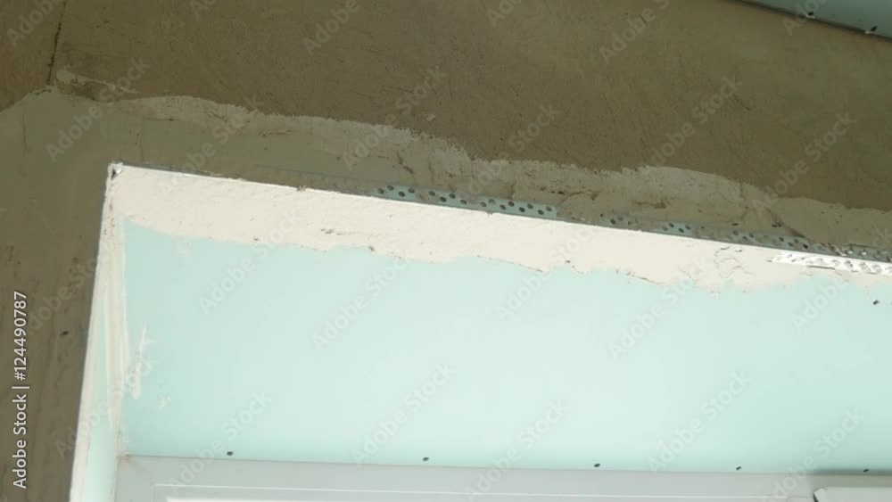 The process of applying the second layer of putty spatula on the sides of the window The process of applying the second layer of putty spatula on the sides of the window