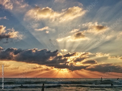 Sun rays radiating from behind cloud during sunset