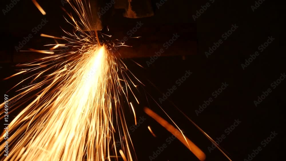Construction worker using an angle grinder producing a lot of sparks
