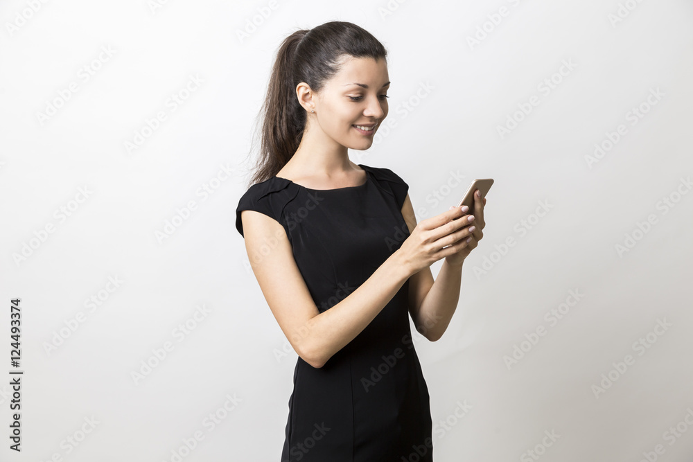 Woman in black dress is looking at her cell phone screen Woman in black dress is looking at her cell phone screen