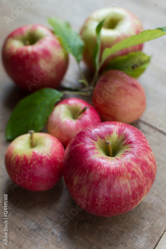 Apples on a wooden backgroound, one with leaves