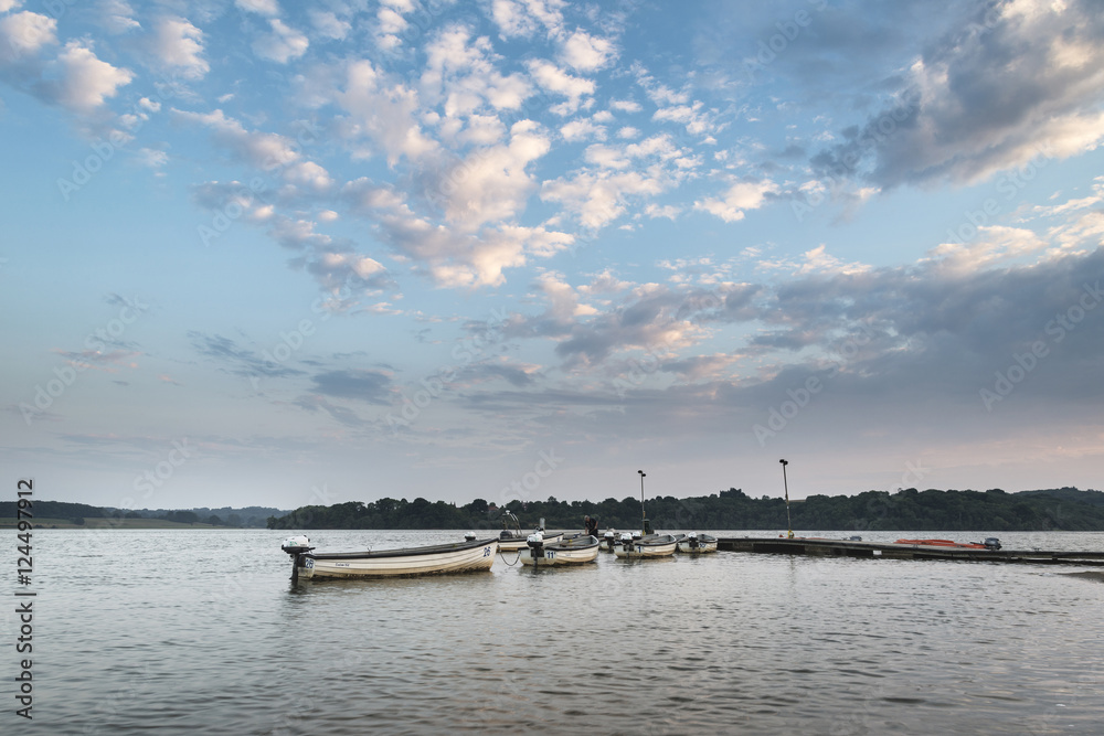 Summer susnet landscape image over reservoir with leisure boats