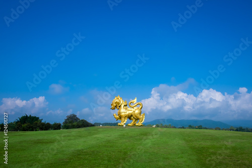 Gold Singha statue on blue sky background
