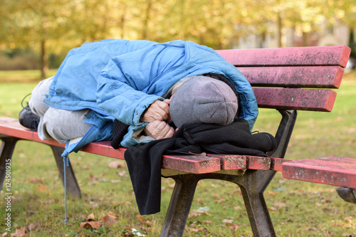 Homeless elderly woman sleeping rough in a park