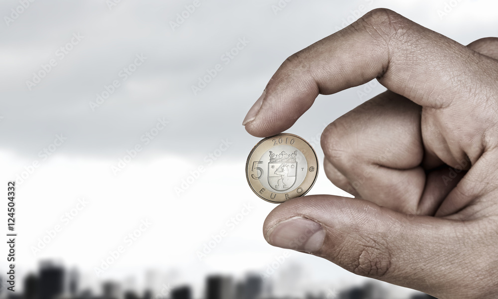 Five euro coin between fingers . Mixed media Five euro coin between fingers . Mixed media