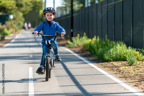 Happy boy riding his bicycle on bike lane