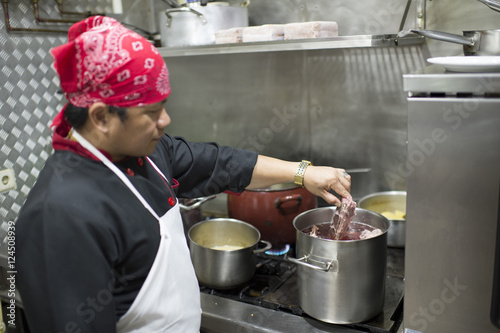 Fototapeta Naklejka Na Ścianę i Meble -  Hispanic cook in diner kitchen