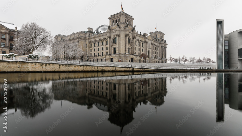 Berlin, Germany Winter The Reichstag is reflected in the cold waters of the Spree.