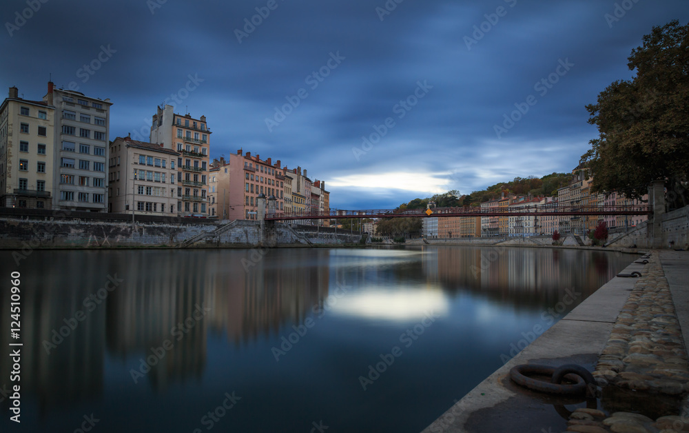 Dark clouds above the Saone river and .Passerelle Saint-Vincent in Lyon at dusk.