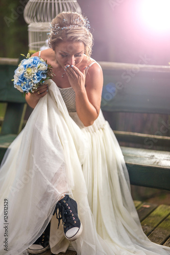 Bride at wedding day with wrong shoes in the park
