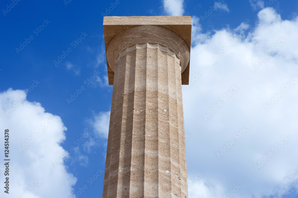 Ancient Greek pillars at the Athens acropolis with blue cloudy sky in the background