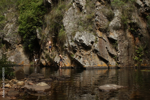people on the rocks and enjoying a swim