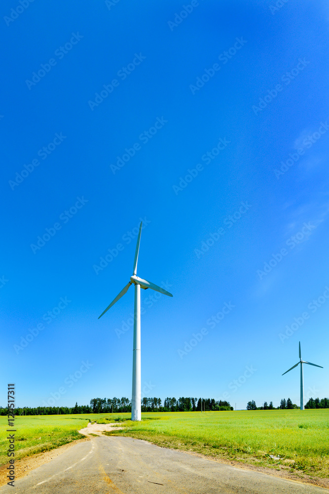Wind generator in the meadows, on a background of blue sky. Wind generator in the meadows, on a background of blue sky.