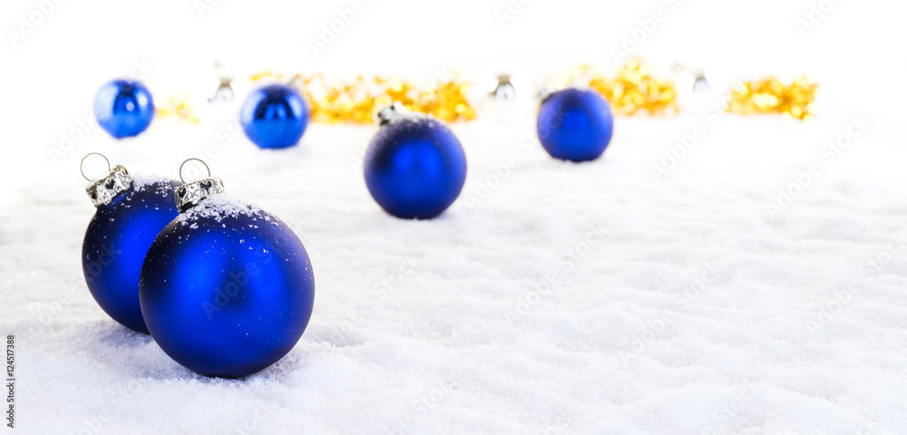 Blaue Weihnachtskugeln und goldenes Geschenkband  im Schnee, Panorama