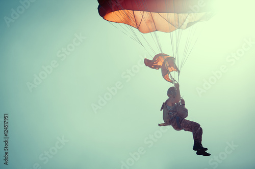 Photo Skydiver On Colorful Parachute In Sunny Clear Sky.