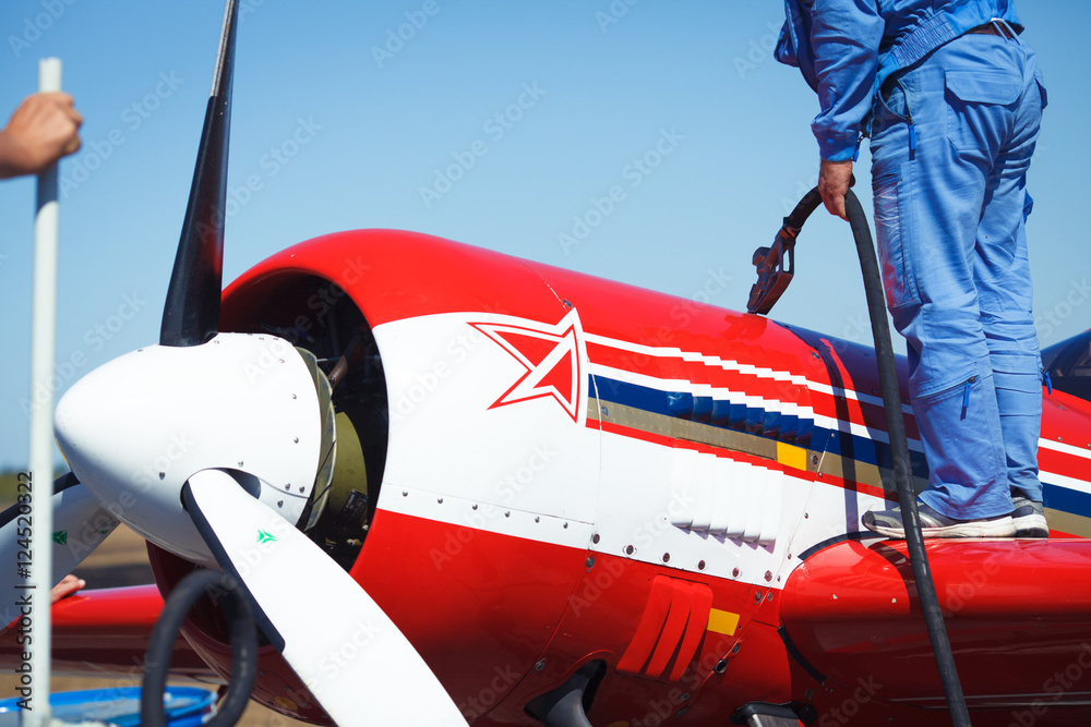 Fototapeta premium Man re-fueling a single engine airplane