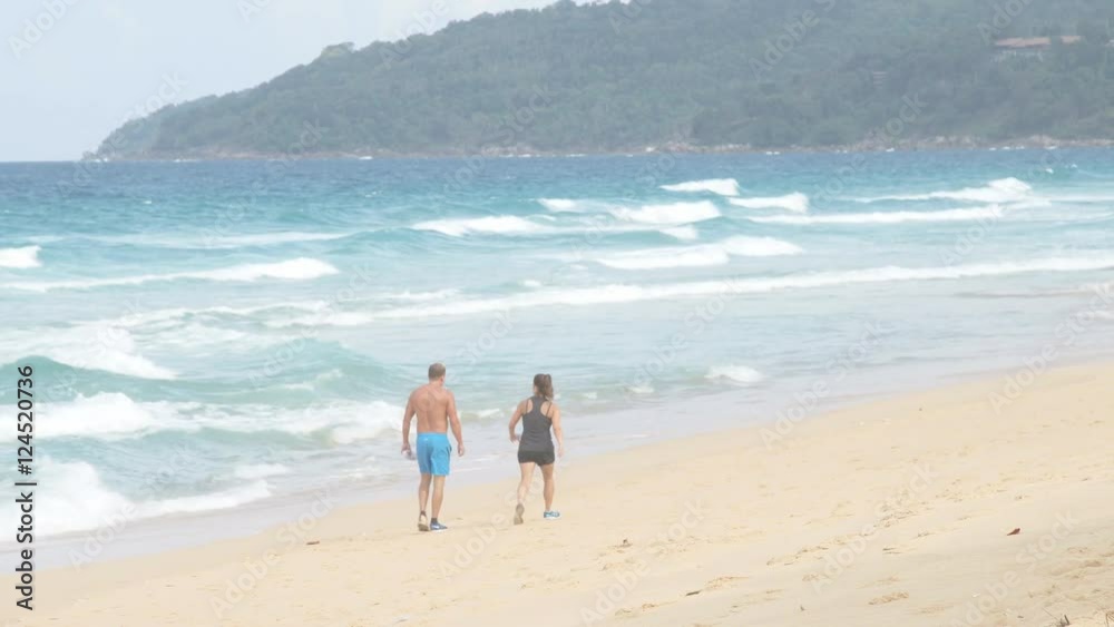 Man and woman walking along the seashore. Couple resting on the beach. Man and woman walking along the seashore. Couple resting on the beach.