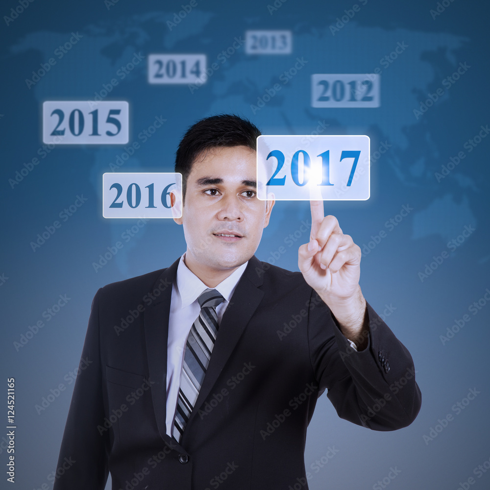 Man presses numbers 2017 on virtual button Man presses numbers 2017 on virtual button