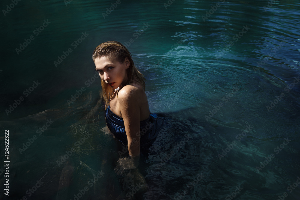 Fashion shoot of woman in long blue dress in water Fashion shoot of woman in long blue dress in water