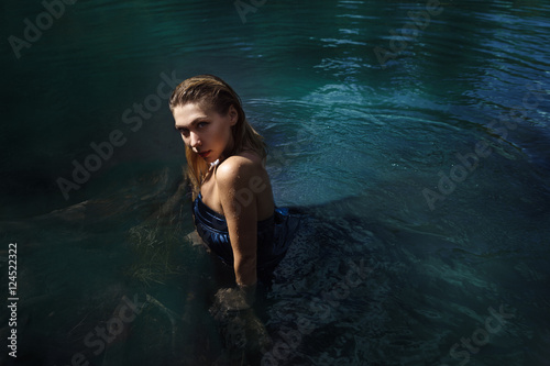 Fashion shoot of woman in long blue dress in water