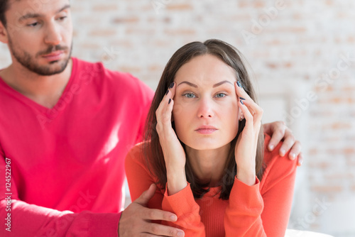 Depressed attractive woman pressing her hands to the head