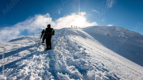 tourists enjoying high mountains in snow on a sunny day