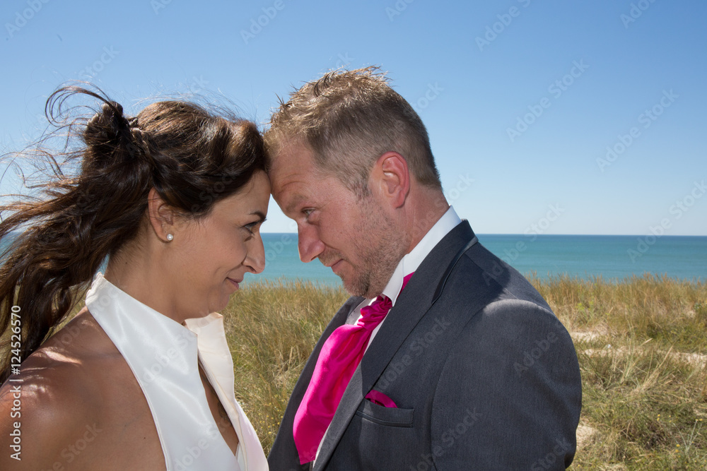 Cheerful married couple standing on the beach Cheerful married couple standing on the beach