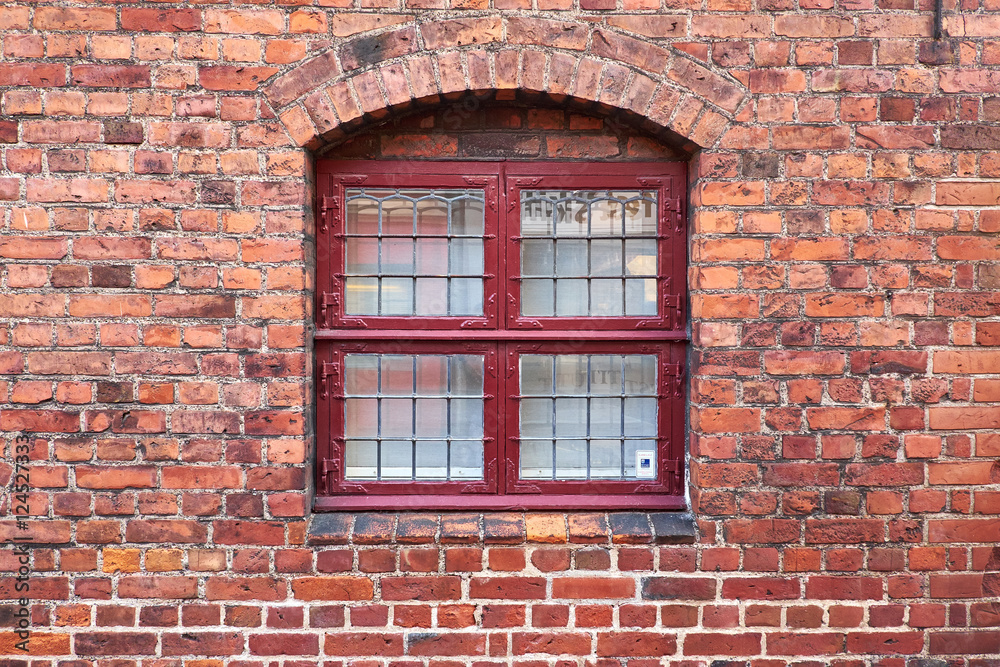 Old leaded painted wood window in an arched red brick wall in a townhouse in Elsinore, Denmark