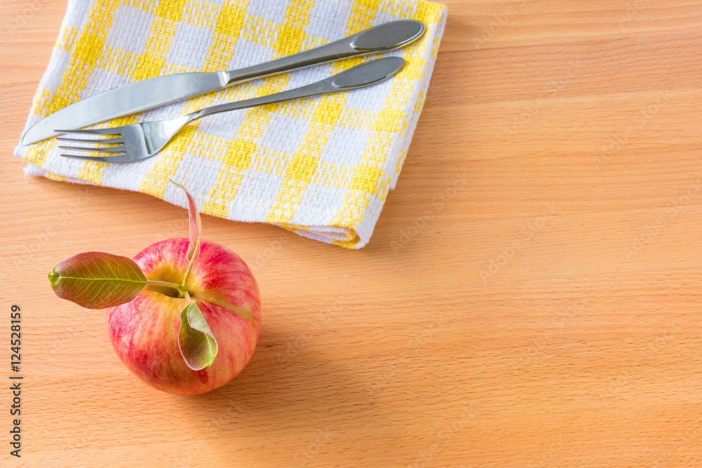 Red apple and napkin with silverware on wooden background. Diet Red apple and napkin with silverware on wooden background. Diet