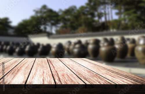 wooden table in front of blurred background of Jar fermented kimchi