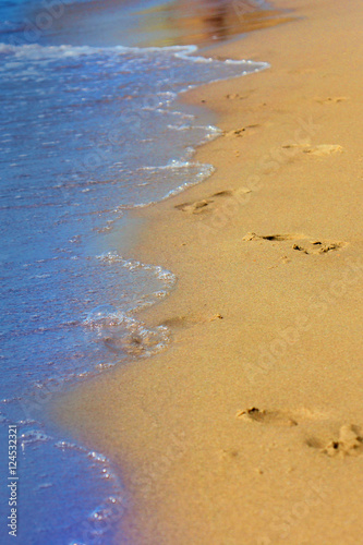 Footprints on sandy beach at sunrise