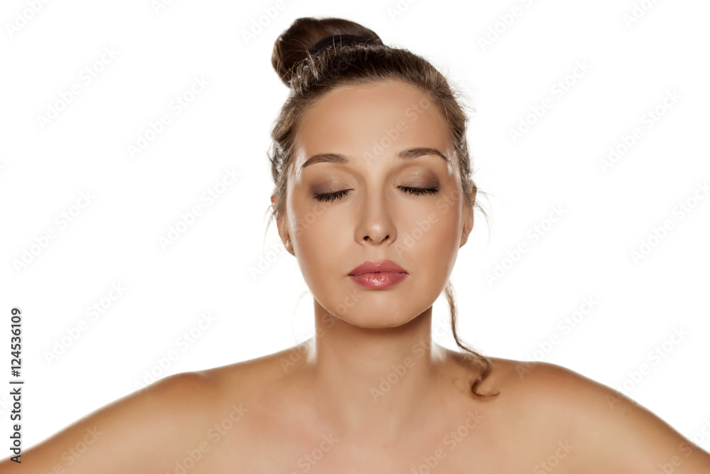 serious young beautiful woman with a bun and closed eyes serious young beautiful woman with a bun and closed eyes