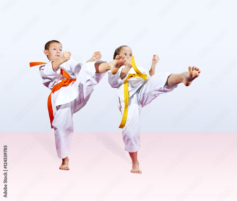 In karategi boy and a girl are beating kick leg