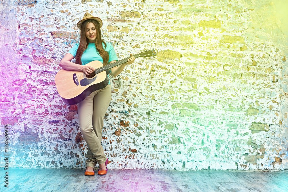 Obraz premium teenager style portrait of young woman playing acoustic guitar