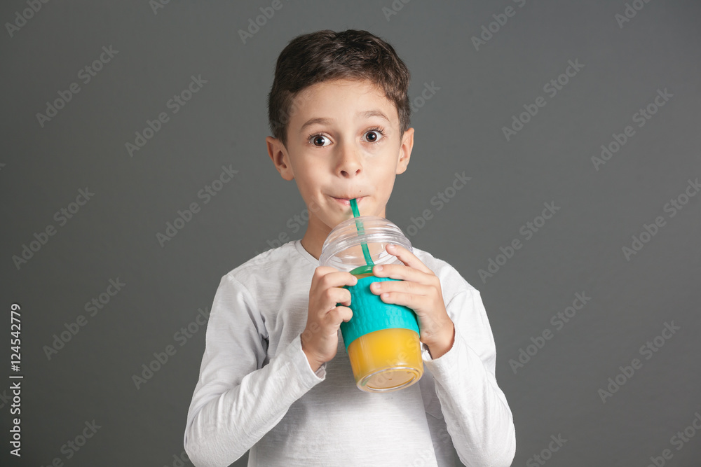 Little funny boy drinking a fresh juice through a straw Little funny boy drinking a fresh juice through a straw