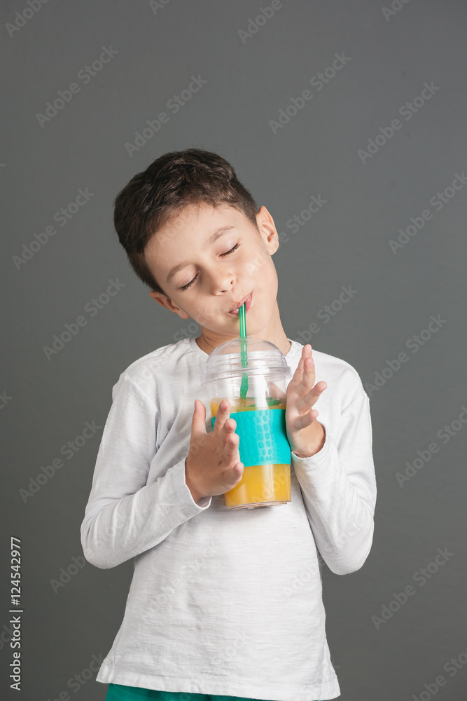 Little funny boy drinking a fresh juice through a straw Little funny boy drinking a fresh juice through a straw