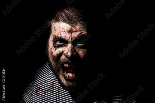 Vampire halloween man. Portrait of blood thirsty vampire man with blood dripping fangs - closeup.
