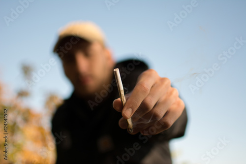 Ein Mann hält einen Joint in der Hand