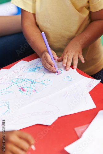 Hands of child painting on paper