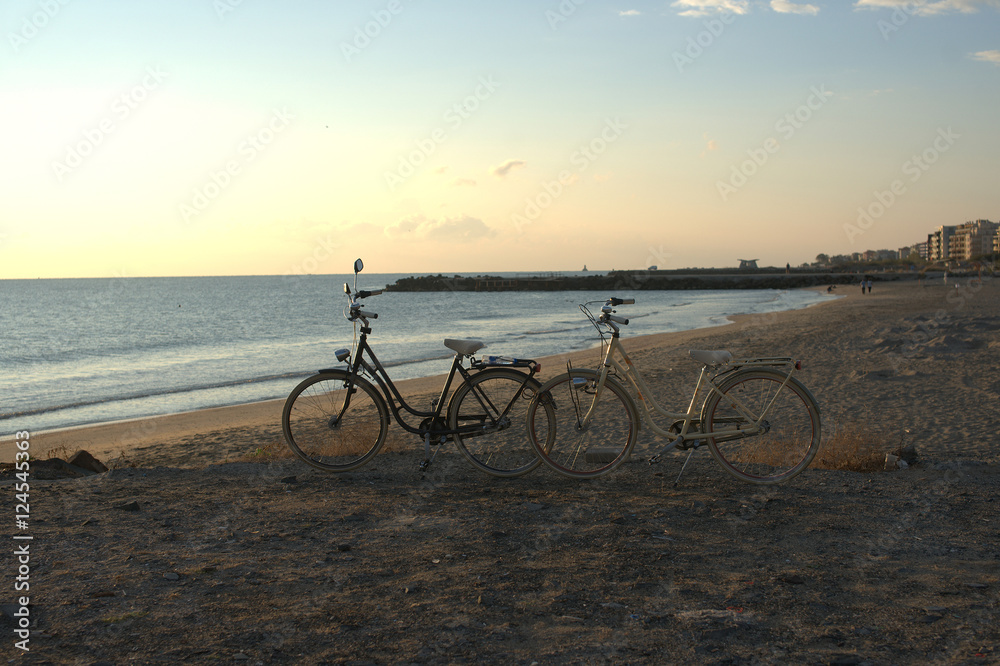 Fototapeta premium Two bikes on the beach at dawn