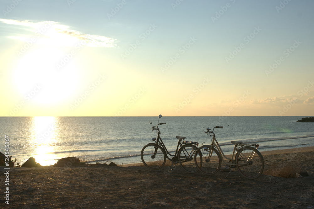 Fototapeta premium Two bikes on the beach at dawn