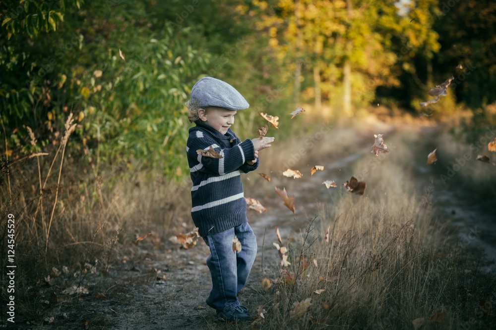 Happy little boy playing outdoor in beautiful autumn scenery Happy little boy playing outdoor in beautiful autumn scenery