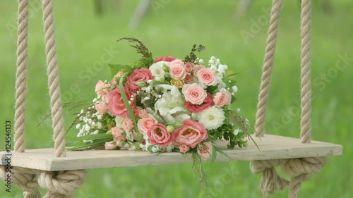 Flowers on wooden swing green background