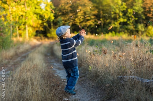 Happy little boy playing outdoor in beautiful autumn scenery © milosz_g