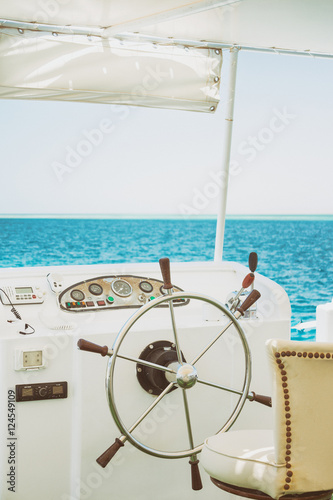steering wheel white yacht on a background of blue sea
