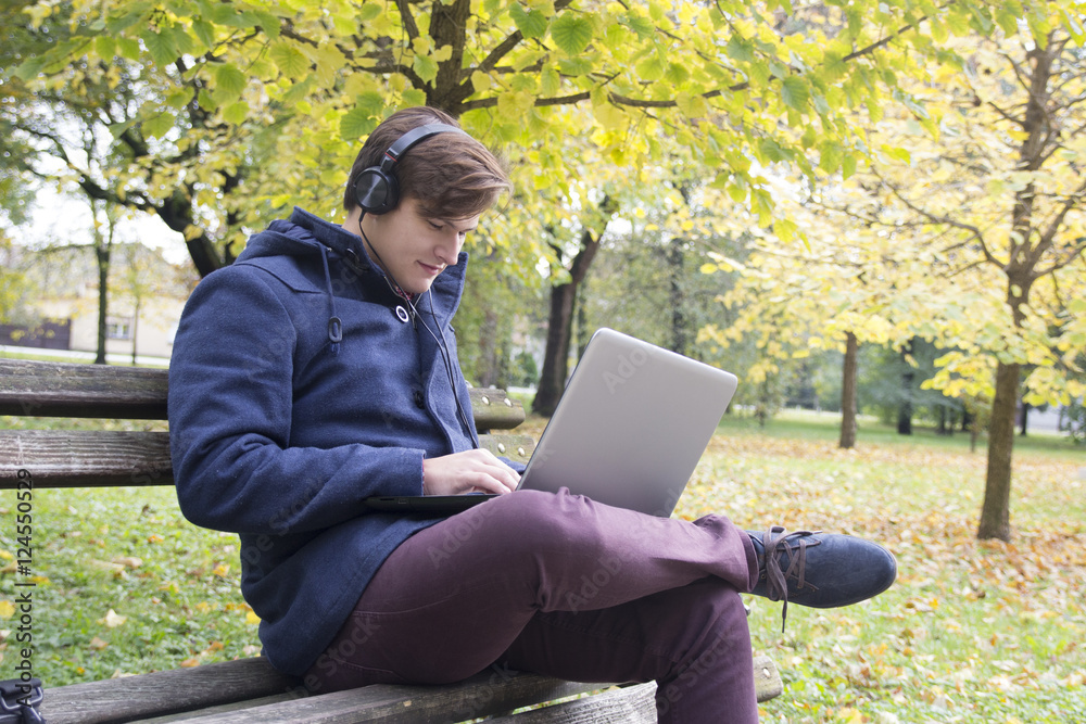 Young man with laptop in the park Young man with laptop in the park